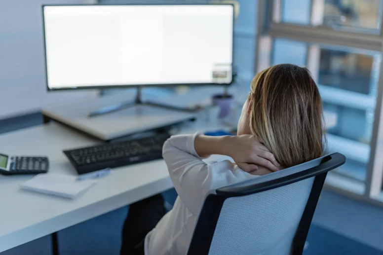 Lady with sore neck from laptop use in office in Newcastle